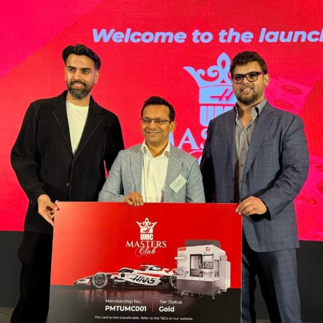 Three men in suits pose with a large red 'UMC Masters Club' card on a launch stage backdrop.